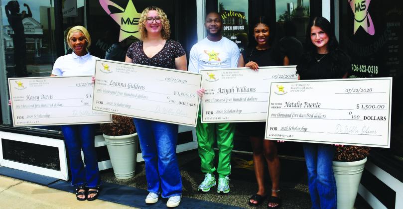 Dr. Willie Oliver (center) presented $1,500 scholarship checks to PCHS graduates (l-r) Kasey Davis, Leanna Giddens, A’Ziyah Williams, and Natalie Puente, May 29 in front of Most Valuable Smiles in Eatonton.