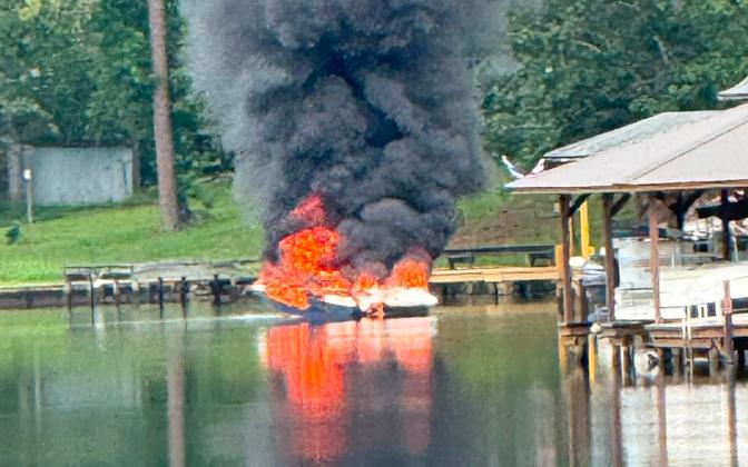 Flames seem to leap from the boat before firefighters arrive.