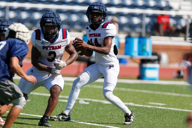 Putnam County quarterback Caleb Reeves (14) drops back in the pocket with running back Elijah Dunn (3) providing pass protection during a padded camp in Eatonton last month. LANCE McCURLEY/Staff