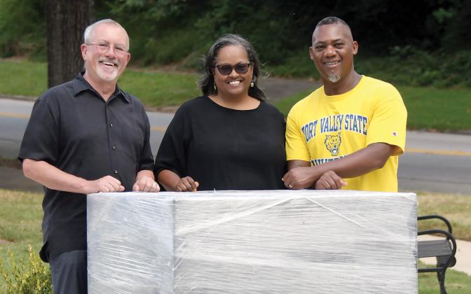 L-R: Kevin Tomson-Hooper is joined by Simone and Grady Jones, posing with the block of granite that will soon support a bronze statue of Eatonton’s own Hiram Little. IAN TOCHER/Staff