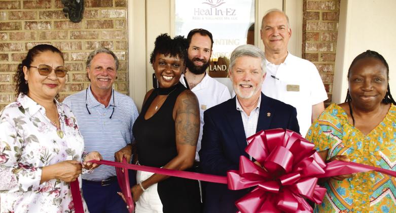 Latonya Taylor (third from left) prepares to cut the ribbon to officially open her Heal In-Ez Reiki &amp; Wellness Spa Aug. 5, in a ceremony hosted by the Eatonton-Putnam Chamber of Commerce. IAN TOCHER/Staff