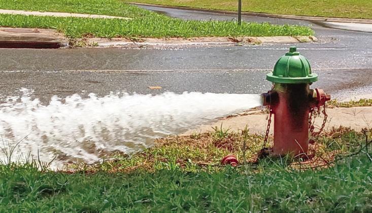 An uncapped fire hydrant alongside Eatonton’s Willie Bailey Street relieves water pressure to allow repairs further down the line. BRANDON PARK/Staff