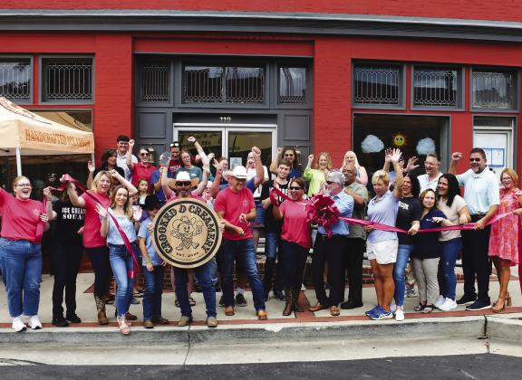 Crooked D Creamery founders and owners David Hodge (center, with scissors) and his wife, Jesse (center, sunglasses), welcomed a sizable crowd of well-wishers May 28 for their official ribbon cutting ceremony at 110 N. Jefferson Ave., in downtown Eatonton.