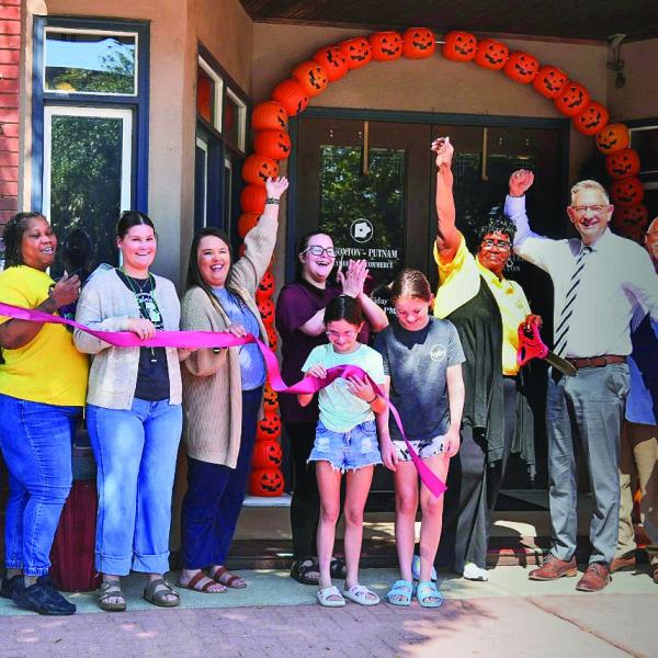 A large group of local well-wishers, including Eatonton Mayor John Reid (4th from right) and his wife Janie (far left), joined several other downtown business owners in welcoming Toys for Tots to a ribbon-cutting ceremony in front of the Eatonton-Putnam Chamber of Commerce offices on East Marion Street. CONTRIBUTED