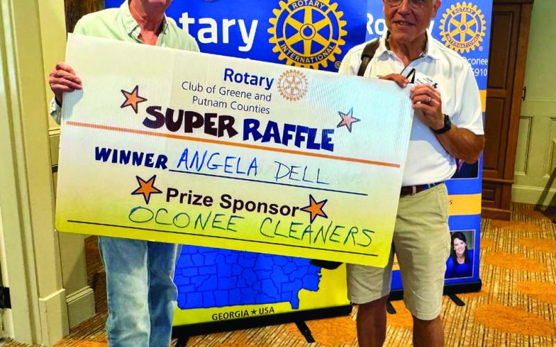 Rotarians Lee Rhodes (left) and John Stenson awarded services at Oconee Cleaners (in-store only) valued at $300 to Rotary Raffle No. 21 prize winner Angela Dell, who was unavailable for the photo. CONTRIBUTED