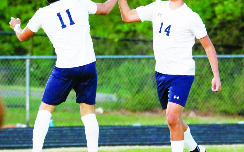 Putnam County senior striker Emmanuel Meraz (11) and sophomore midfielder Alexander Jimenez (14) high-five after a goal was scored against Oglethorpe County. LANCE MCCURLEY/Staff