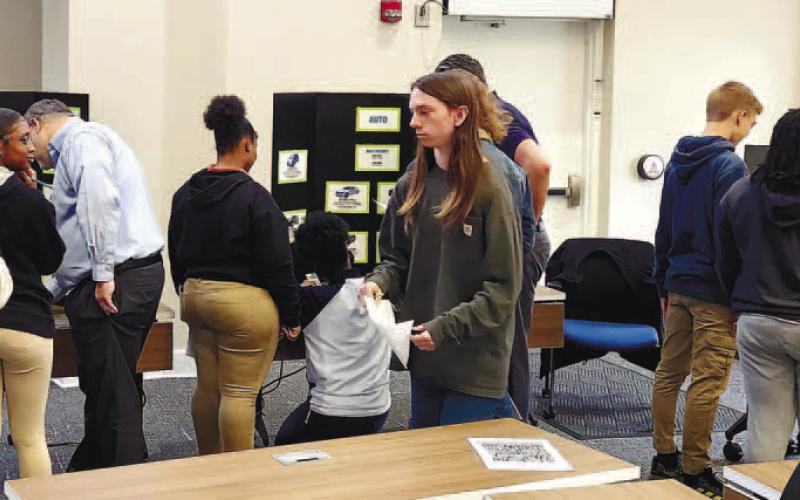 Students visit each station to see how they can budget and spend their money on different things a 26-year-old adult would have to manage in their life. KARA LASSITER/Contributed