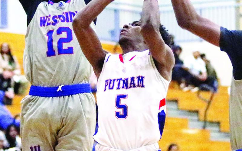 Putnam County junior Jaylin Harper (5) goes up a contested layup against a pair of Westside defenders. LANCE MCCURLEY/Staff