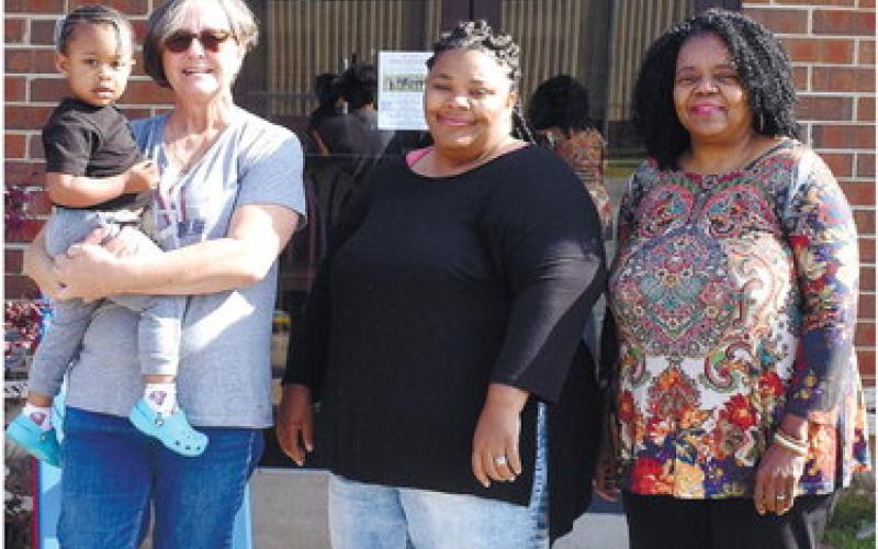 volunteer Shelby Beauchamp holding Mazi Mathis, volunteer Lynda Farley and Executive Director Vanessa Jackson standing outside PCO. BAILEY BALLARD/File Photo
