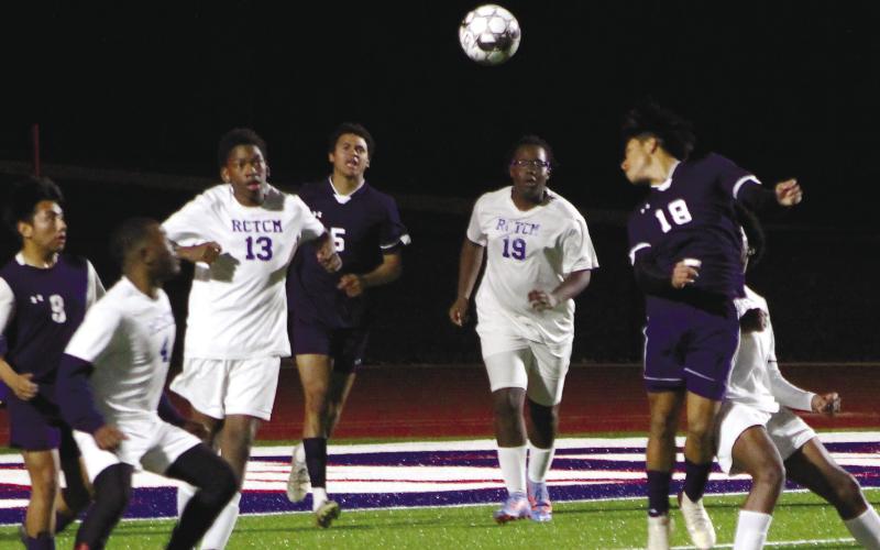 Christian Hernandez (18) floats a header over defenders. KIM CASH/Staff