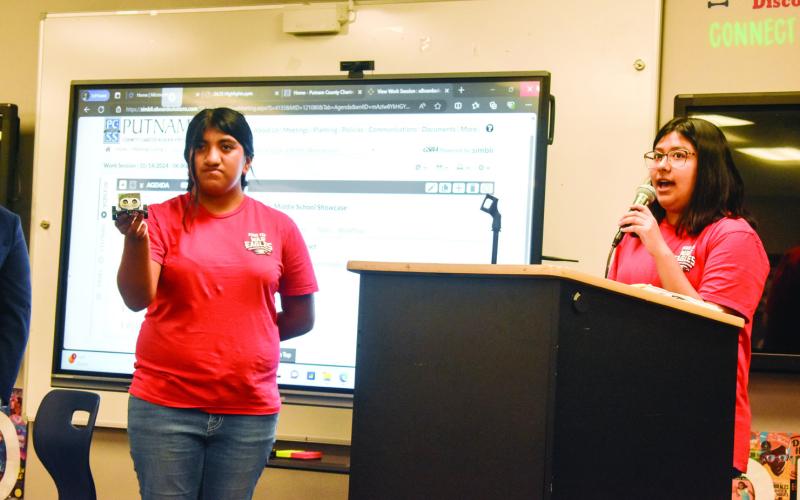 The PCMS Technology Student Association president (right) discusses her experience coding the robot presented by her classmate. BAILEY MCCULLY/Staff