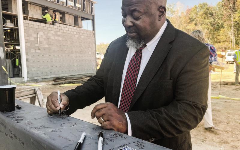 Putnam County Charter School System Superintendent Derick Austin adds his signature to a large metal beam that will soon be added to the structure of a brand-new Putnam County Elementary School. IAN TOCHER/Staff