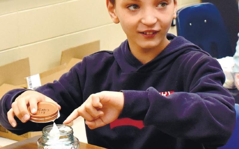 After adding the shaving cream, Elijah Carson is getting ready to close his jar and make a tornado. LENA HENSLEY/Staff