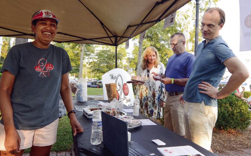 Le Cordon Bleu-trained chef Karen Garrett (left) of Dot 2 Dot Inn in Eatonton served up delicious specialty items from her Taste of Eatonton booth, while her husband Richard Garrett (right) provided support. LEIGH LOFGREN/Staff