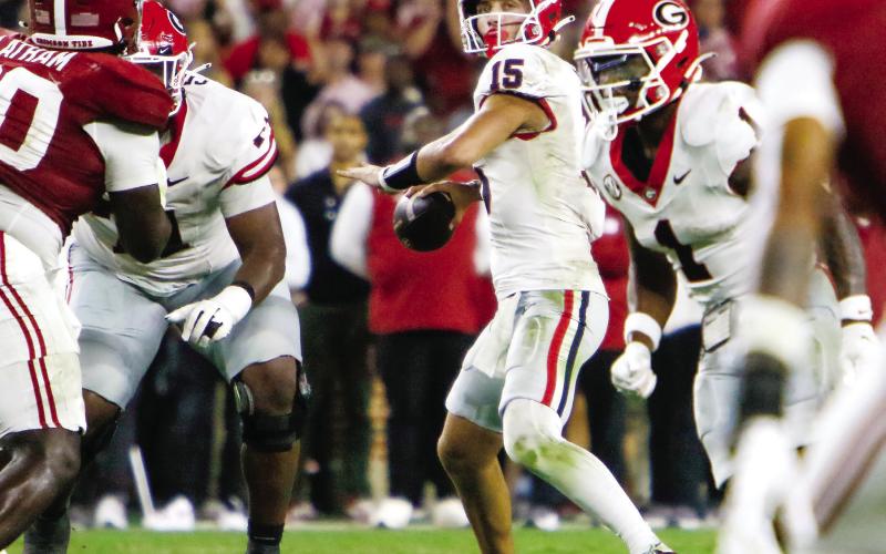 Georgia quarterback Carson Beck (15) drops back to pass before throwing a game-ending interception in the end zone. LANCE McCURLEY/Staff