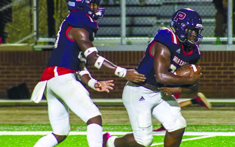 Jalon Kilgore (23) hands the ball off to Putnam County running back Tamarion Peters (27). LANCE McCURLEY/Staff