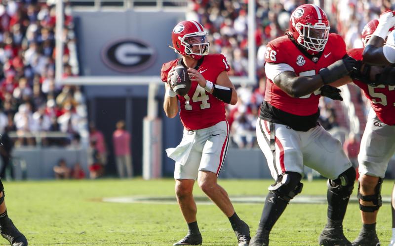 Georgia quarterback Gunner Stockton (14) drops back to pass from the pocket during a game against Ole Miss last season. LANCE McCURLEY/Staff