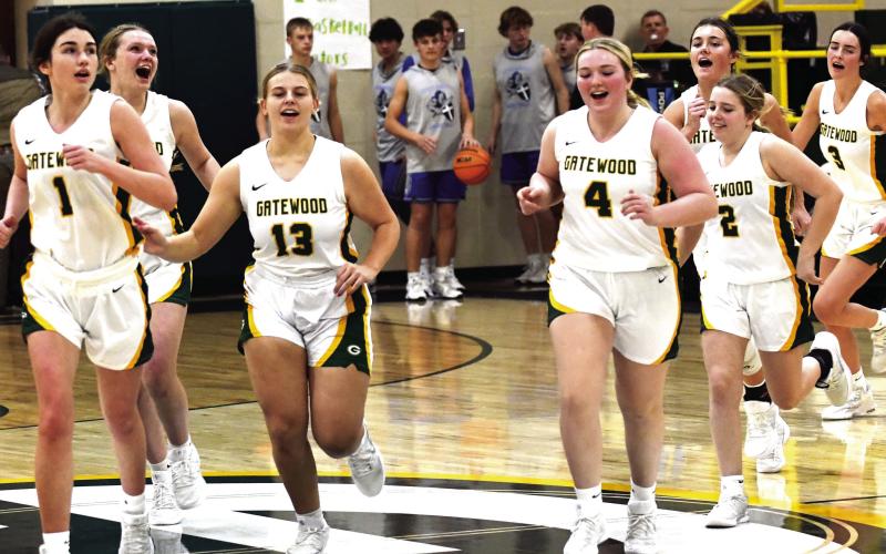 The Lady Gators, including Lauren Paxson (1), Avery Hill (13), Lily Huskins (4), Sylvie Huskins (2), and Riley Roberts (3) run off the court following a recent win in Eatonton. IAN TOCHER/Staff