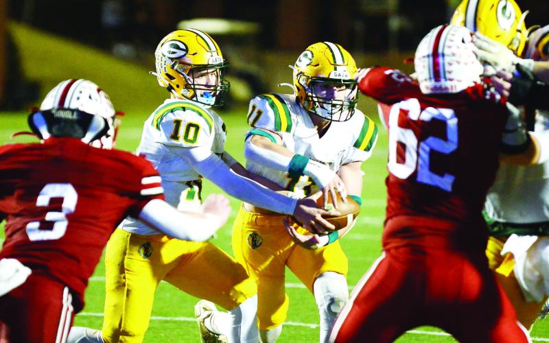 Gators junior quarterback Ames Johnson (10) completes a handoff in heavy traffic to running back Mason Sinclair (11). IAN TOCHER/Staff