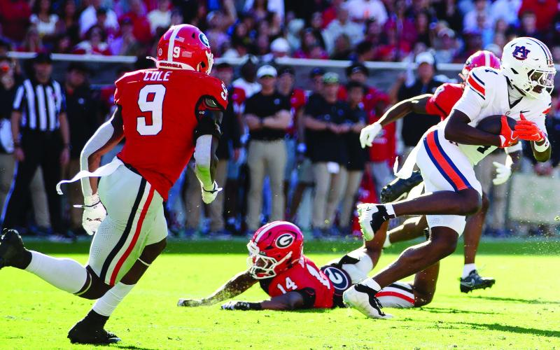 Auburn receiver Jeremiah Koger (4) gets away from Georgia’s Chris Cole (9) and Rasean Dinkins (14). SKYLA MORRIS/Staff