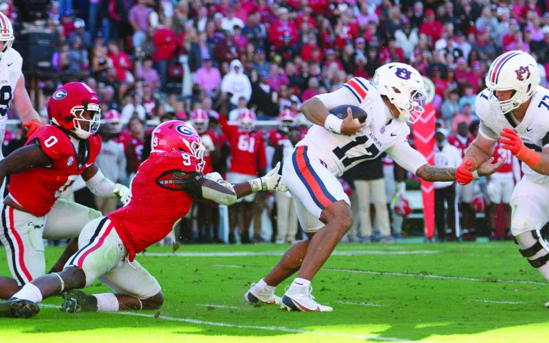 Auburn quarterback Byrum Brown (17) hurt the Bulldogs on the ground with 26 carries for 115 yards and a touchdown, evading linebackers Gabe Harris (0) and Chris Cole (9) throughout the afternoon. SKYLA MORRIS/Staff