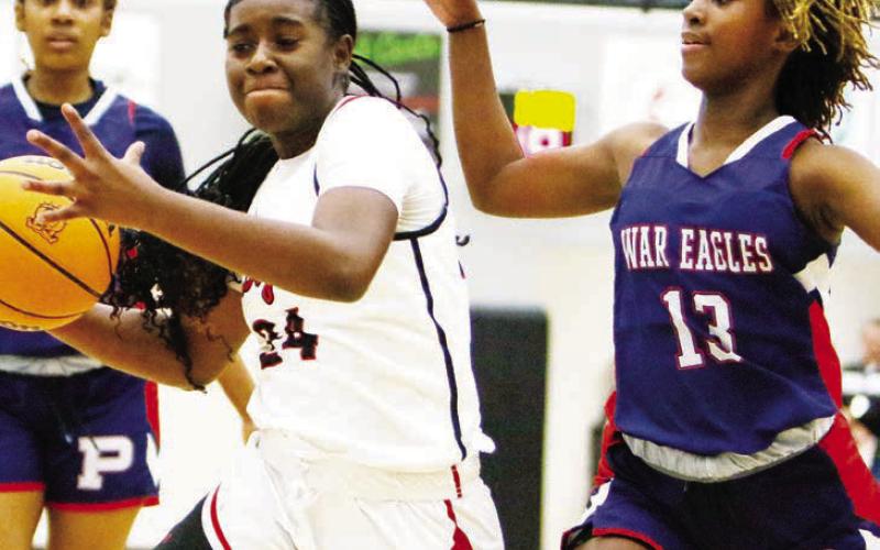 Putnam County’s Kadyn Dennis (13) attempts to stop Morgan County’s Cydney Burke (24) from driving to the basket. LANCE McCURLEY/Staff