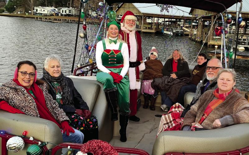 Santa and his head elf pose with cruise attendees Dec. 18 before setting out for Christmas Cove. BAILEY MCCULLY