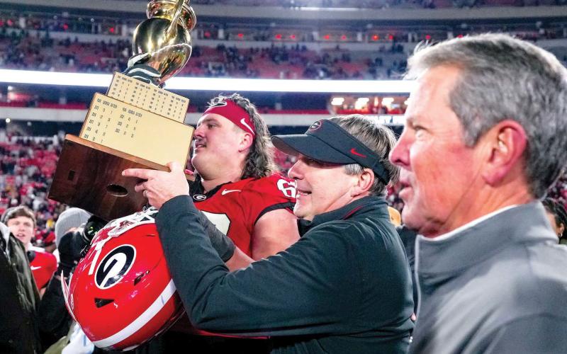Georgia Gov. Brian Kemp (right) joins Georgia head coach Kirby Smart on the field on the field after the Bulldogs defeated Georgia Tech last season. FILE PHOTO