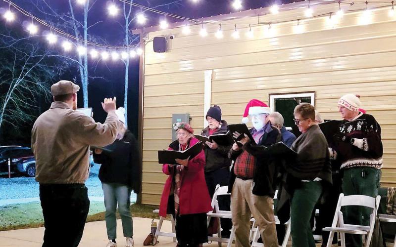The Milledgeville Singers Club performs carols outside of the Holiday Market. BAILEY BALLARD/Staff