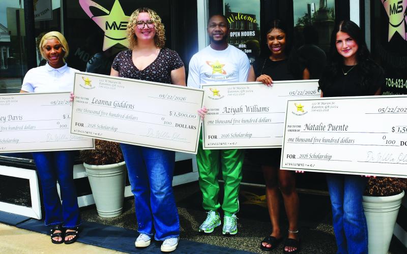 Dr. Willie Oliver (center) presented $1,500 scholarship checks to PCHS graduates (l-r) Kasey Davis, Leanna Giddens, A’Ziyah Williams, and Natalie Puente, May 29 in front of Most Valuable Smiles in Eatonton.
