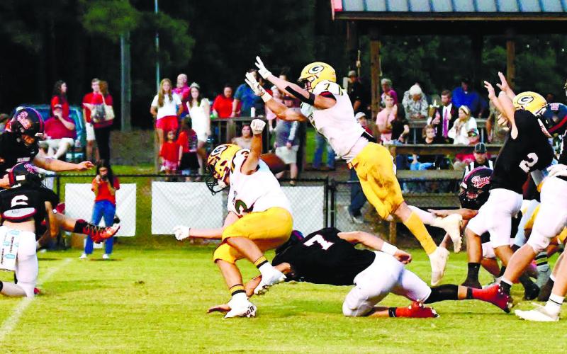 Gatewood’s Evan Bennett (7) leaps forward to successfully block a point-after-touchdown attempt by Briarwood kicker Trey Cotton. (Ball is directly behind the shoulders of Jackson Hewatt (3). DAWN SINCLAIR