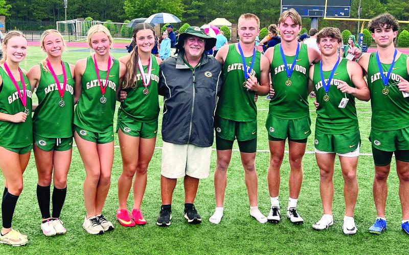 Gatewood track-and-field head coach Jeff Ratliff stands between his third-place girls 4X100 relay team and the record-setting boys 4X400 relay team at the 2025 GIAA 3A State Track &amp;amp; Field Meet. CONTRIBUTED