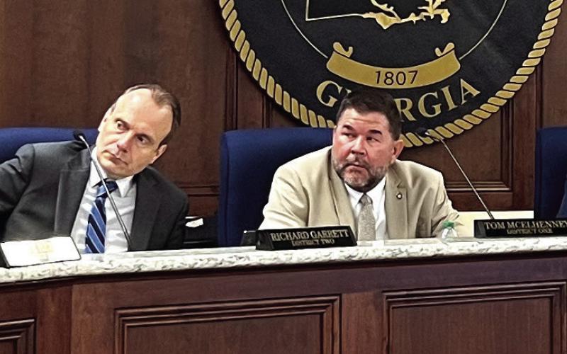 L-R: District 4 Commissioner Jeff Wooten speaks as Dr. Steve Hersey (Dist. 3), Richard Garrett (Dist. 2), Tom McElhenney (Dist. 1), Commission Chair Bill Sharp, County Attorney Adam Nelson, and County Manager Paul Van Haute look on April 4 during a scheduled commission meeting. IAN TOCHER/Staff