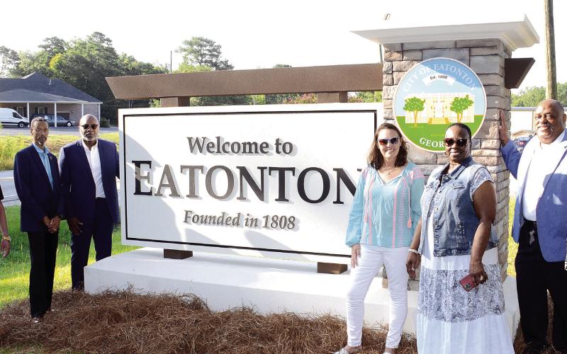 L-R: Eatonton Councilmembers Chip Walker, James Gorley, Michael Smith, Marie Rainey, Janie Reid, Mayor John Reid, and Mylle Mangum proudly show off brand-new signage heading into the city from its north side. IAN TOCHER/Staff