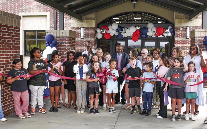 Along with several Putnam County Elementary School students at the ribbon cutting, Putnam County Board of Education Superintendent Derick Austin (center, pink tie) was joined by BOE board members Charles Trumbo (left, back row), BOE Chair Dr. Steve Weiner (sunglasses), and (l-r, back row,) Doris Clemons, Carol Ann Guthrie, and Rev. Simone Jones. PCES Principal Whitney Smith is standing to Austin’s right. IAN TOCHER/Staff
