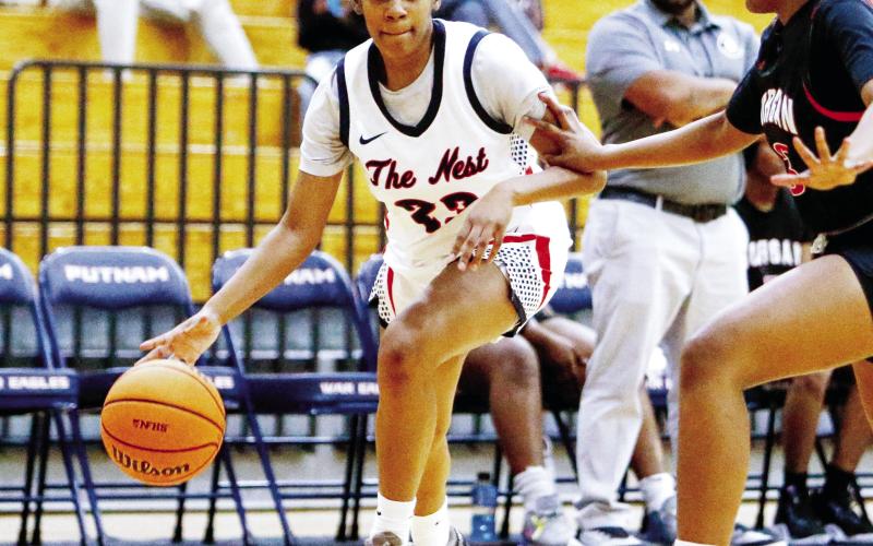 Putnam County senior forward A’ziyah Williams (23) dribbles the ball inside the key past a Morgan County defender in last week’s win over the Dogs on Nov. 22. LANCE McCURLEY/Staff