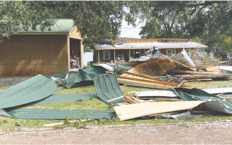 Allen Jordan used a skid steer to create a pile of the roofing materials that were scattered around his yard. LYNN HOBBS/Staff