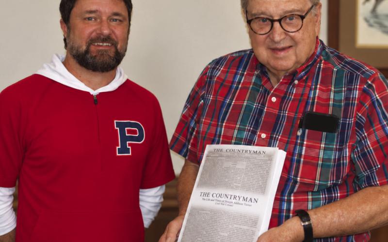 E-PCHS president Jim Marshall presents a copy of The Countryman to Smith Communications’ graphic designer Brandon Park, who did the layout and design work . A. MARK SMITH/Staff