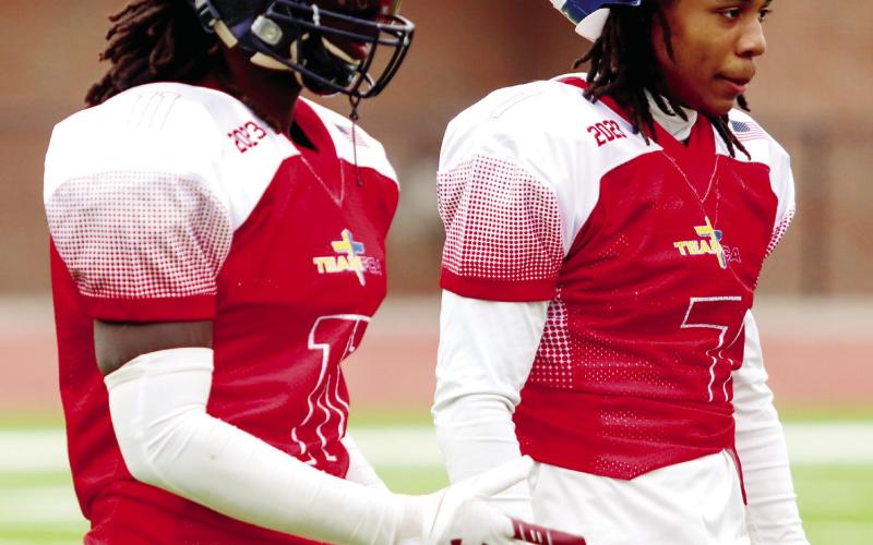 Waller (left) walks off the field during a timeout with a teammate from Cedar Shoals High School of Athens during the FCA All-Star game. LANCE MCCURLEY/Staff