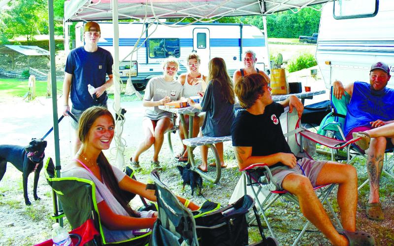 Members of three families: the Guinns, the Armistads, and the Prestons of Madison relax in the shade near their camper during their first visit to Oconee Springs Park.