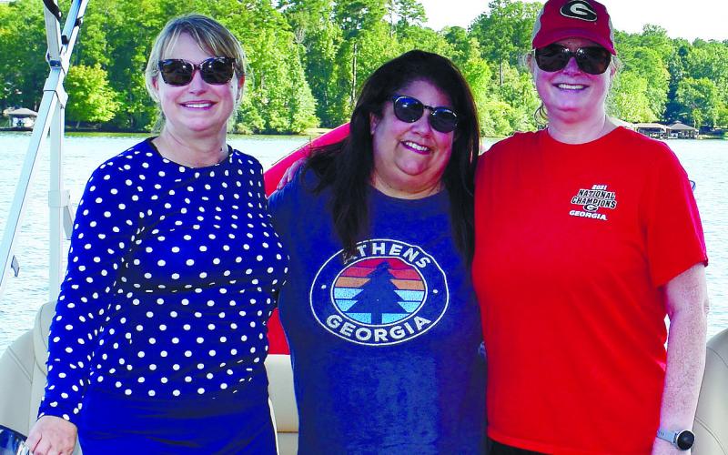 Dianna Odom of Eatonton, along with Kathleen Amsterdam and Lauven Cherneau of Roswell, prepare to depart on a boat ride.