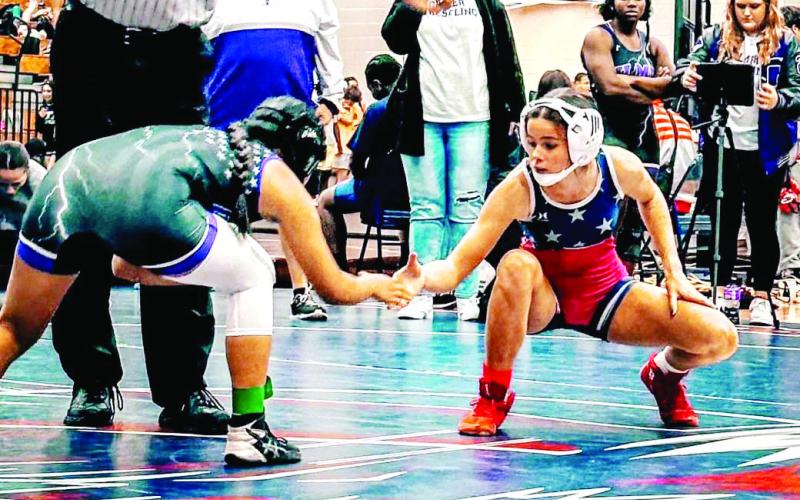 Putnam County’s Lily Frisch (right) shakes hands with a competitor. ARELLA CASH/Staff