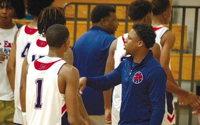 Nick Banks (right) talks to his brother Eren (left) during a timeout of a home game last season. CONTRIBUTED
