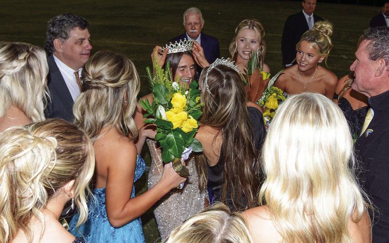 Backed up by her dad Jeff Mansfield and surrounded by senior classmates, 2024 Gatewood Homecoming Queen Sarah Mansfield is crowned by last year’s queen Taylor Moreno, with Gatewood Head of Schools Jeff Decker (right) looking on. IAN TOCHER/Staff