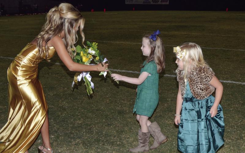 After being escorted by her father Scott Ault, Gatewood senior Anna Scott Ault receives her bouquet from K-5 buddies Olivia Chapman and Lilly Barnett. IAN TOCHER/Staff