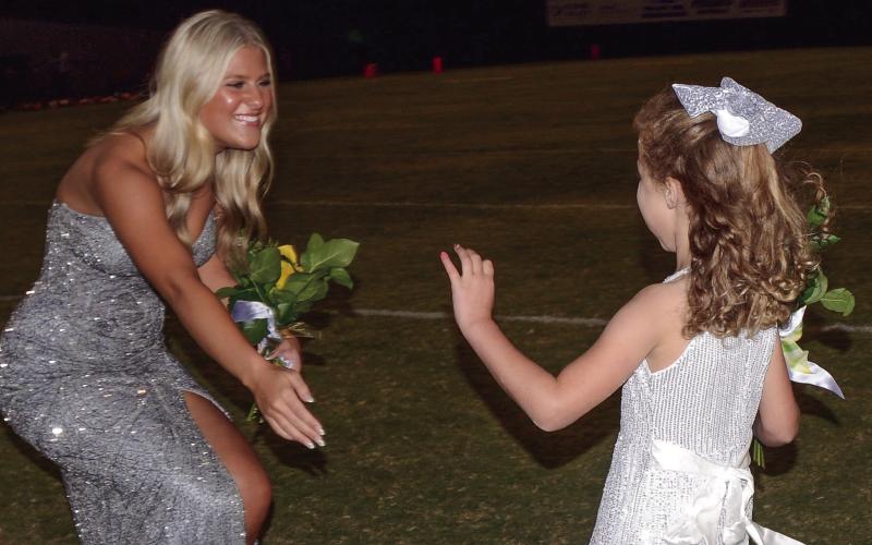 K-5 buddy Abigail Smith delivers flowers to Gatewood senior Ava Rose Clark, escorted by her brother, Austin Clark. IAN TOCHER/Staff