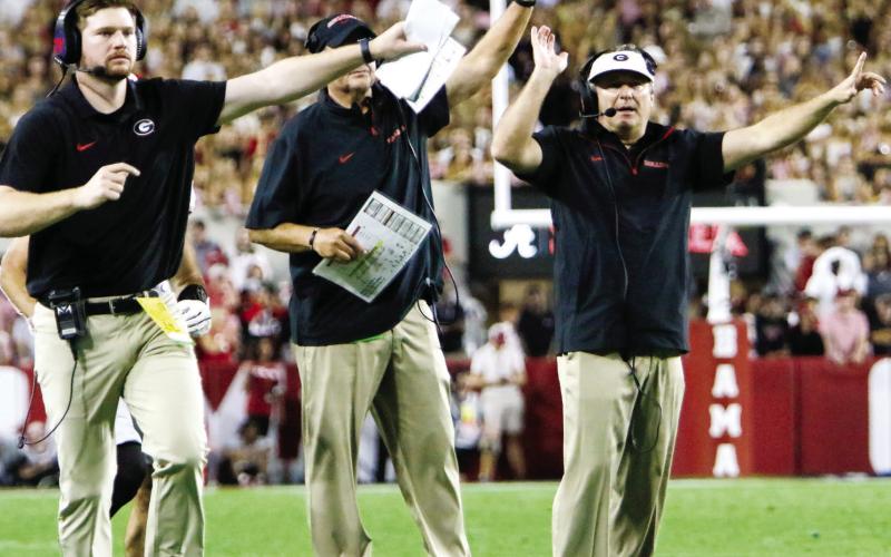 Georgia head coach Kirby Smart (far right) and members of his coaching signal their players to attempt a two-point conversion following a touchdown. LANCE McCURLEY/Staff