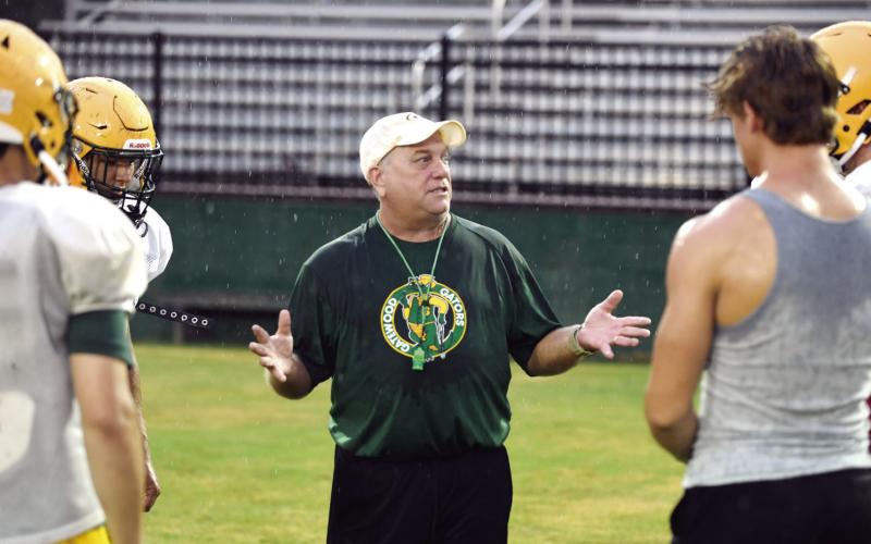 With rain soaking everyone’s shirts and jerseys, Gatewood head coach Jeff Ratliff explains his next drill during practice last Friday at Sammons Field in Eatonton. IAN TOCHER/Staff