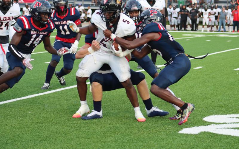 Baldwin running back Micah Welch (5) brought down by Putnam defenders. ARELLA CASH/Staff