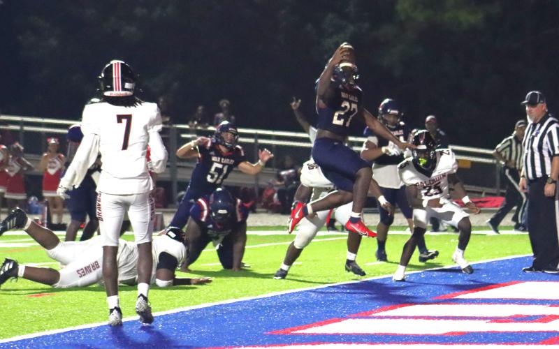 Tamarion Peters (27) glides past defenders into the end zone during the fourth quarter against the Braves on Friday night at Al Reaves Field. ARELLA CASH/Staff